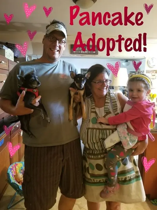 A family posing for a picture with the adopted dog pancake