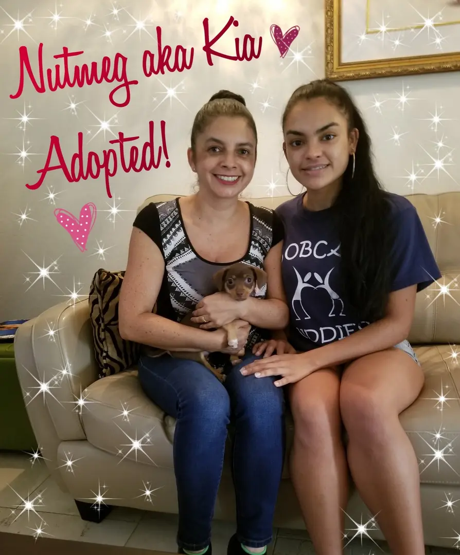 Two young girls holding their adopted dog Nutmeg