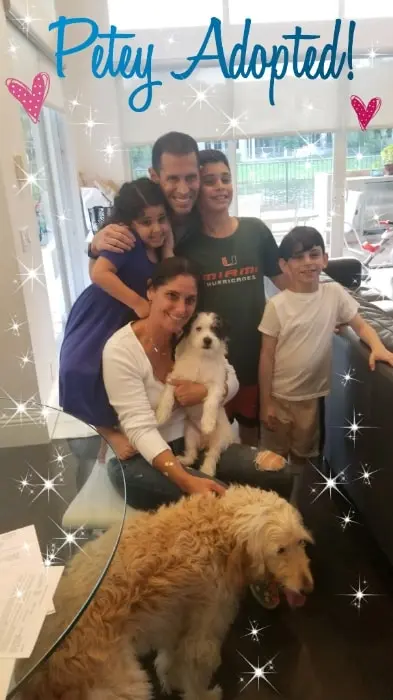 A family posing with their adopted dog Petey